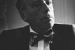 Headshot of a balding man wearing a suit and bowtie with a neutral expression