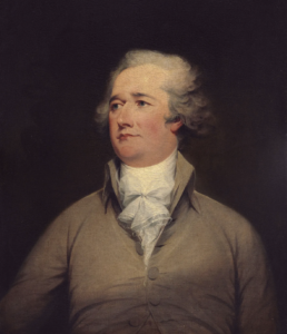 Portrait of a man with bushy grey hair wearing a beige button up shirt and white cravat