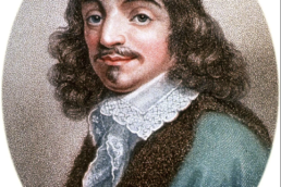 Portrait of a man with long, brown, curly hair, a mustache and goatee wearing a frilled collar