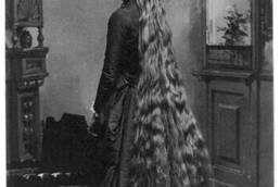 Black and white image of a lady with very long hair wearing an old fashioned dress.