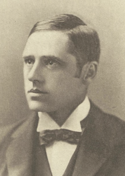 Black and white headshot of a young man with dark hair and a neutral expression wearing a jacket and bowtie